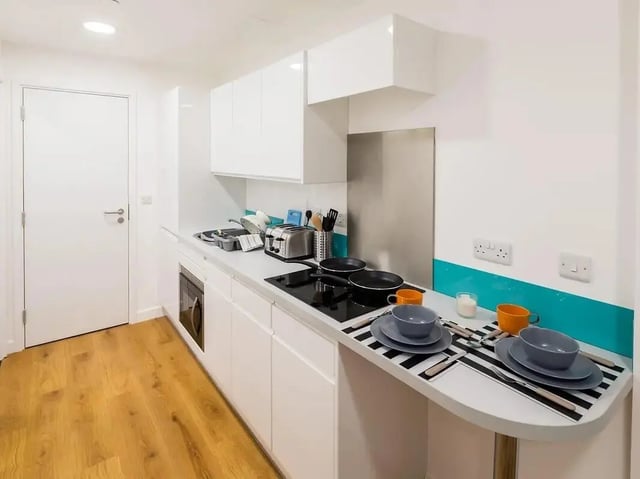 Modern white kitchen with appliances and table setting kitchen at Grand Felda House in Wembley Student Accommodation