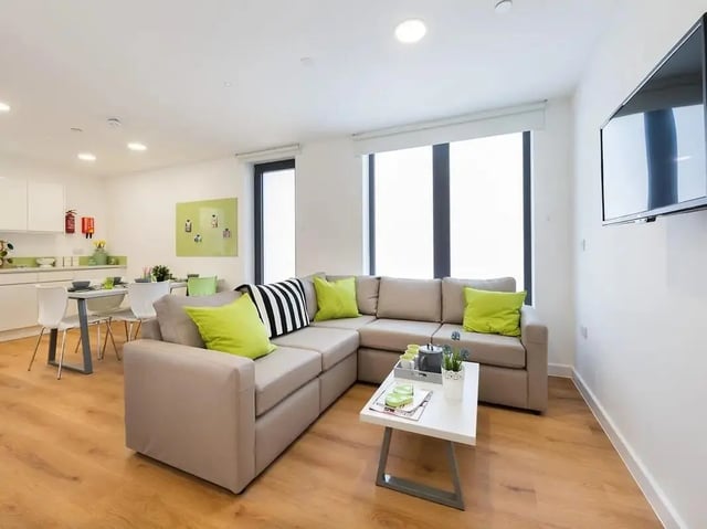 Sofa cushions coffee table kitchen dining area living room at Grand Felda House in Wembley Student Accommodation