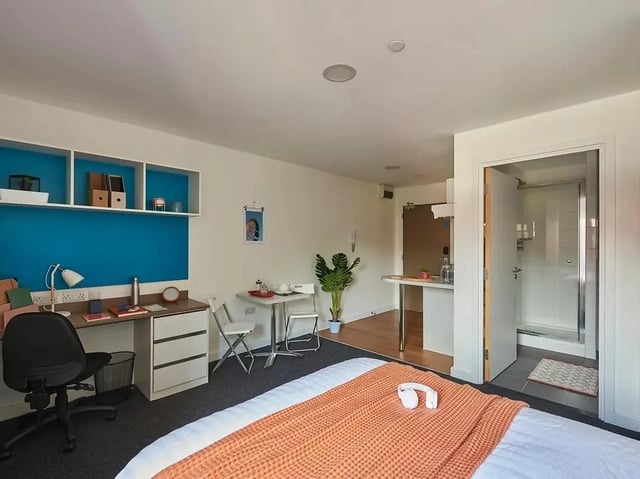 Desk chair table plant and kitchen area Bedroom at Grand Felda House in Wembley Student Accommodation