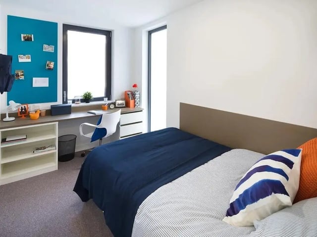 Bed desk chair bookcase and pillows bedroom at Grand Felda House in Wembley Student Accommodation