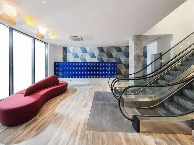 Red sofa blue mailboxes escalator common area at Grand Felda House in Wembley Student Accommodation