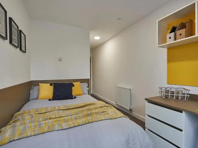 Bed with yellow blanket and pillows, storage Bedroom at Grand Felda House in Wembley Student Accommodation