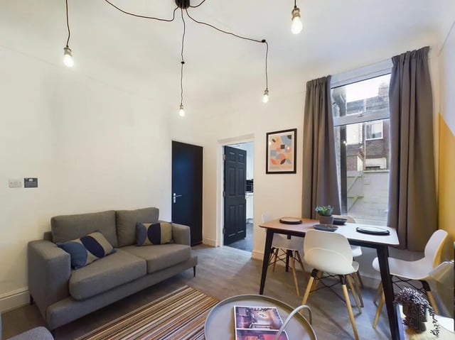 Sofa dining table artwork and lights living room at 4 Bedroom House at 102, Leopold Road in Liverpool Student Accommodation
