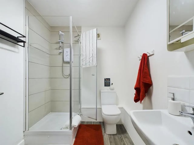 Shower toilet sink red towel bathroom at 6 Bedroom House at 2, Flat 2, Windsor House, Clint Road West in Liverpool Student Accommodation