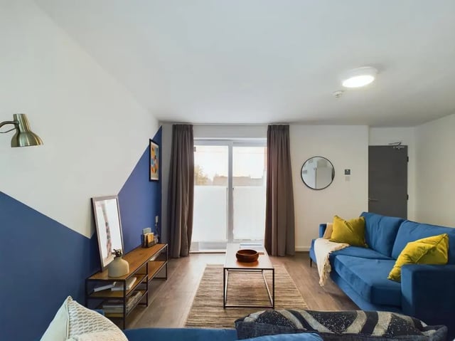 Blue sofa coffee table and patterned rug living room at 6 Bedroom House at 2, Flat 2, Windsor House, Clint Road West in Liverpool Student Accommodation