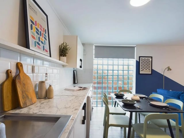 Marble countertops cutting boards plant and poster kitchen at 6 Bedroom House at 2, Flat 2, Windsor House, Clint Road West in Liverpool Student Accommodation
