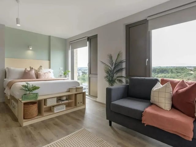 Bed with storage sofa and plant bedroom living area at Yugo Bottleworks in Cork Student Accommodation