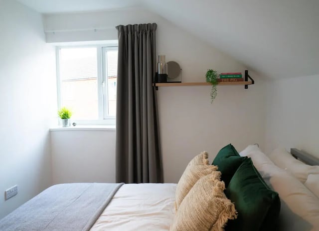 Bed with pillows window and shelf bedroom at 12 Bedroom House at Freya House, Thesiger Street in Lincoln Student Accommodation