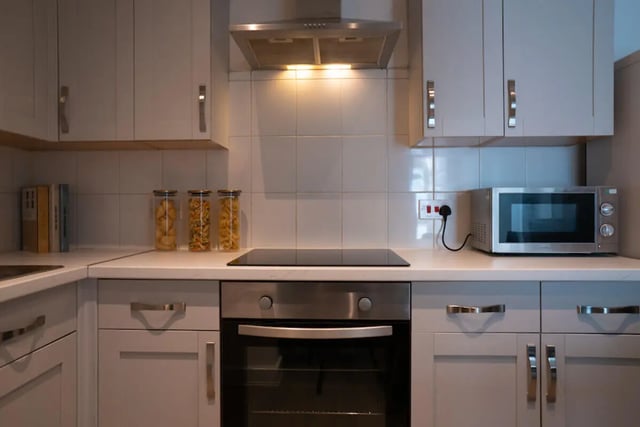 Microwave oven stovetop cupboards jars kitchen at 6 Bedroom House at Loren House, Thesiger Street in Lincoln Student Accommodation