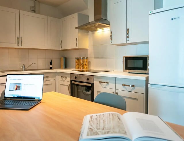 Laptop open book on table kitchen area kitchen at 4 Bedroom House at 119, Oliver House, Canwick Road in Lincoln Student Accommodation