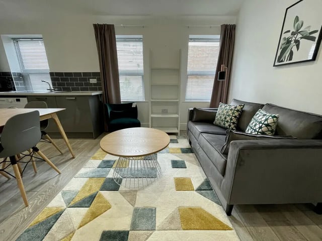 Sofa coffee table rug dining table kitchen living area at 2 Bedroom House at 20 B, Portland Street in Lincoln Student Accommodation