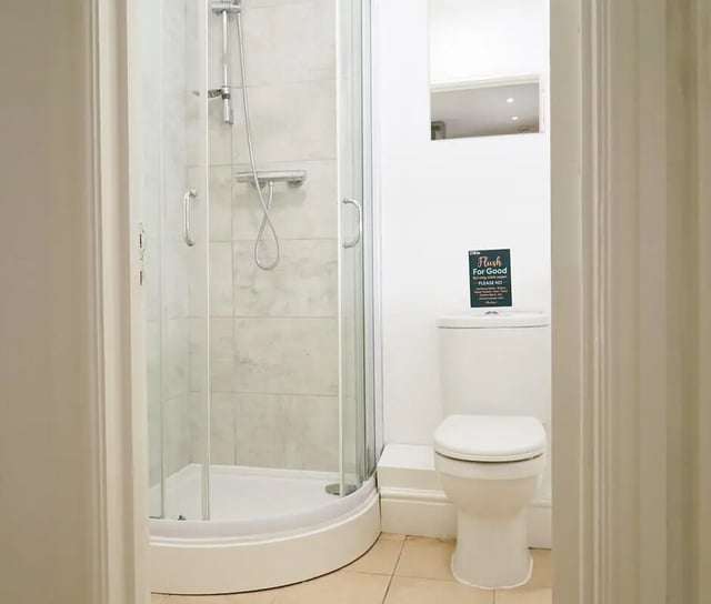 Shower stall and toilet with sign bathroom at 6 Bedroom House at 3, Baggholme Road in Lincoln Student Accommodation
