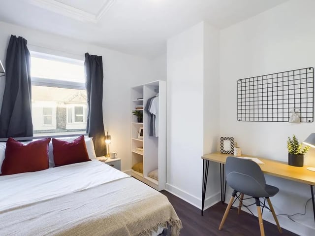 Bed with red pillows wardrobe desk and chair bedroom at 6 Bedroom House at 53, Ripon Street in Lincoln Student Accommodation