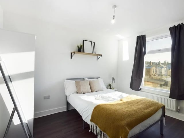 Bed with yellow blanket and mirror bedroom at 6 Bedroom House at 53, Ripon Street in Lincoln Student Accommodation