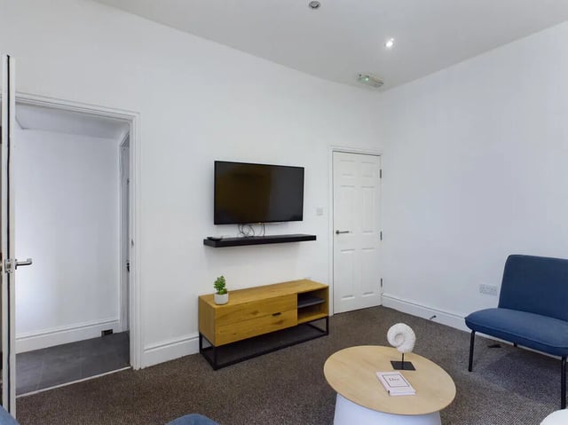 TV unit coffee table blue chair living room at 4 Bedroom House at 107, Hall Lane in Liverpool Student Accommodation