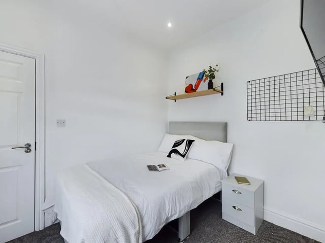 Bed with bedside table and art bedroom at 4 Bedroom House at 107, Hall Lane in Liverpool Student Accommodation