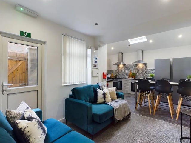 Teal sofas with patterned cushions kitchen area Living room at 6 Bedroom House at 154, Empress Road in Liverpool Student Accommodation