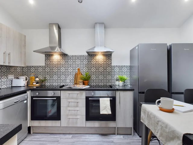 Two ovens with patterned backsplash and refrigerators Kitchen at 6 Bedroom House at 154, Empress Road in Liverpool Student Accommodation