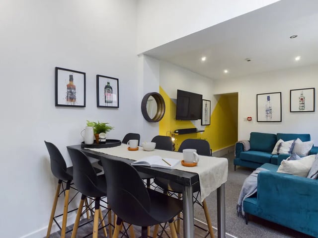 Dining table with stools and sofa living area at 6 Bedroom House at 154, Empress Road in Liverpool Student Accommodation