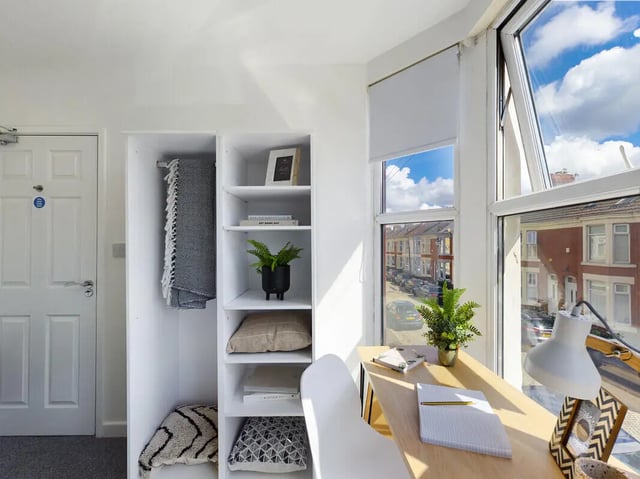 White wardrobe shelves with plant and pillows study area. at 6 Bedroom House at 154, Empress Road in Liverpool Student Accommodation
