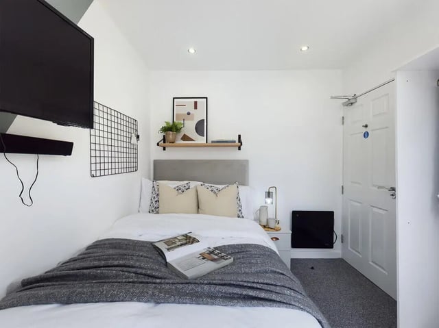 Bed with pillows shelf art and heater Bedroom at 6 Bedroom House at 154, Empress Road in Liverpool Student Accommodation