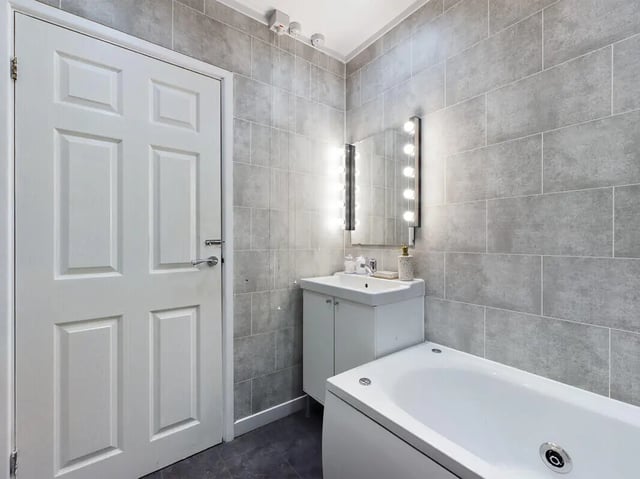 White door sink mirror bathtub grey tiles bathroom at 6 Bedroom House at 154, Empress Road in Liverpool Student Accommodation