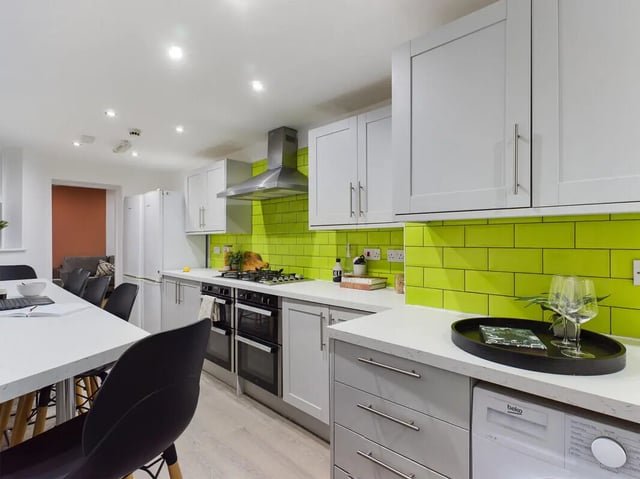 Modern kitchen with white cabinets and bright green tiles kitchen at 8 Bedroom House at 213, Smithdown Road in Liverpool Student Accommodation