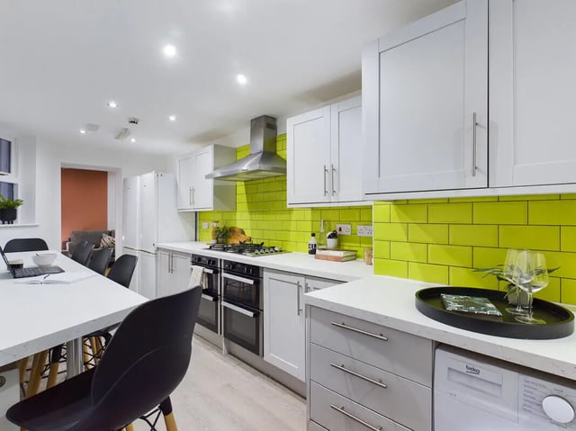 Modern kitchen with white cabinets and lime green backsplash kitchen at 8 Bedroom House at 213, Smithdown Road in Liverpool Student Accommodation
