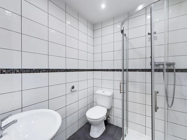 White tiled bathroom with sink toilet and shower. Bathroom at 8 Bedroom House at 213, Smithdown Road in Liverpool Student Accommodation