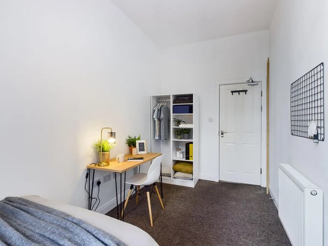 Desk plants lamp shelves closet and bed study area at 8 Bedroom House at 213, Smithdown Road in Liverpool Student Accommodation