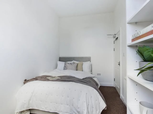 Bed with white duvet and grey throw bedroom at 8 Bedroom House at 213, Smithdown Road in Liverpool Student Accommodation