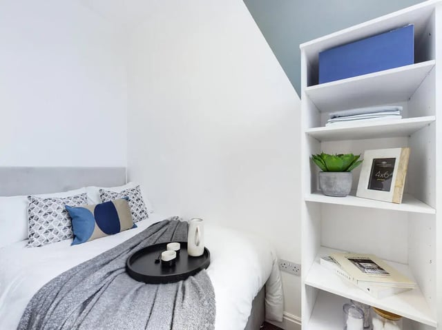 Bed with pillows tray and bookshelf bedroom at 8 Bedroom House at 213, Smithdown Road in Liverpool Student Accommodation