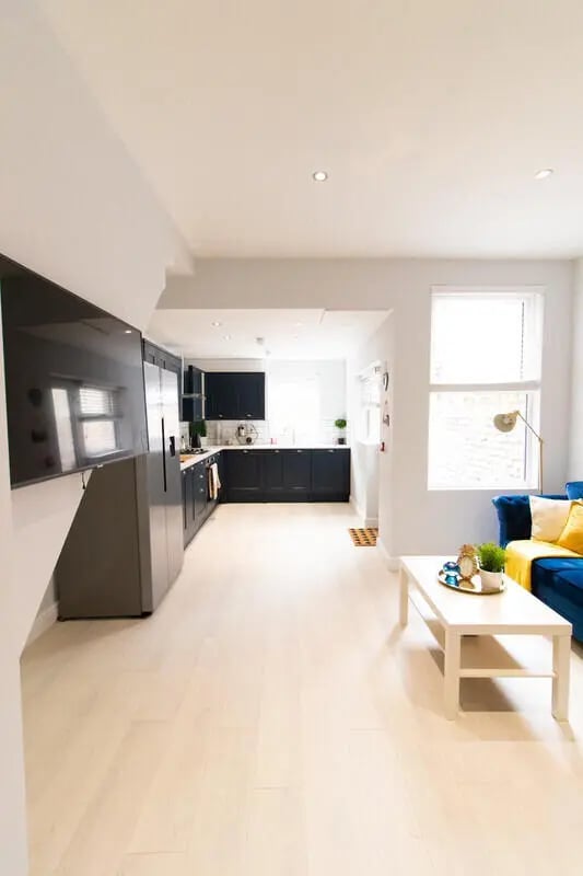 Modern kitchen and living area with blue sofa living room at 6 Bedroom House at 85, Halsbury Road in Liverpool Student Accommodation