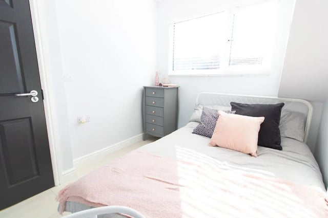Bed with pillows and pink blanket bedroom at 6 Bedroom House at 85, Halsbury Road in Liverpool Student Accommodation