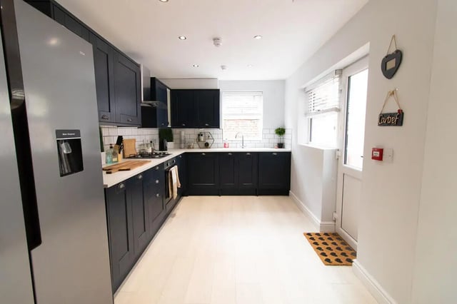 Fridge dark cabinets white counter stove kitchen at 6 Bedroom House at 85, Halsbury Road in Liverpool Student Accommodation