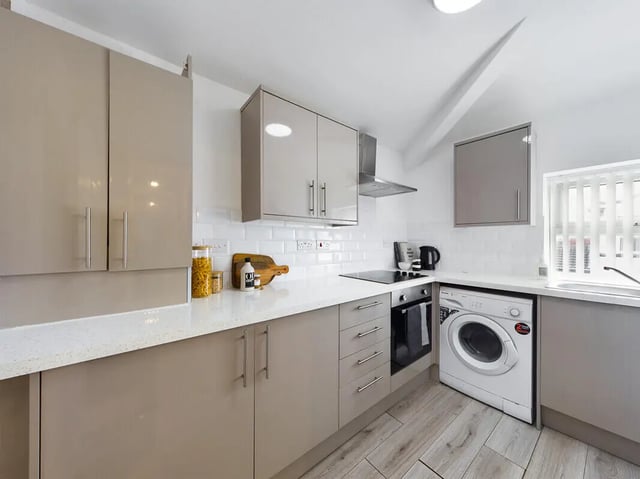 Tan cabinets stove oven washing machine kitchen at 9 Bedroom House at 76, Burleigh Street in Manchester Student Accommodation