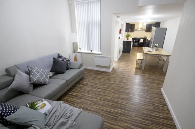 Grey sofa and dining table with bench living area at 6 Bedroom House at 3, Crofton Street in Manchester Student Accommodation