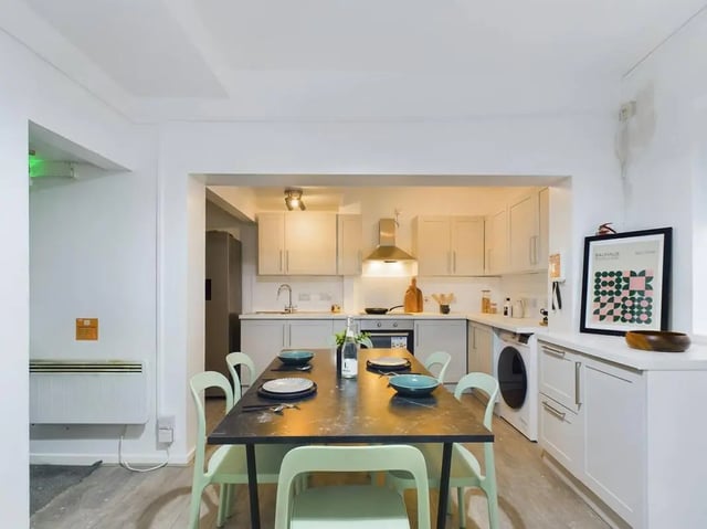 Dining table with chairs and kitchen area. at 7 Bedroom House at 5, CYRIL STREET in Manchester Student Accommodation