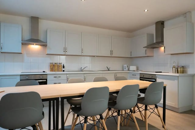 Table chairs stove cabinets and sink kitchen at 3 Bedroom House at Flat 1, 34, RUSKIN AVENUE in Manchester Student Accommodation