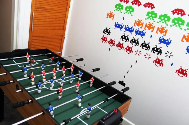 Foosball table with pixelated aliens on wall playing area at 4 Bedroom House at 16, Lovat Road in Preston Student Accommodation