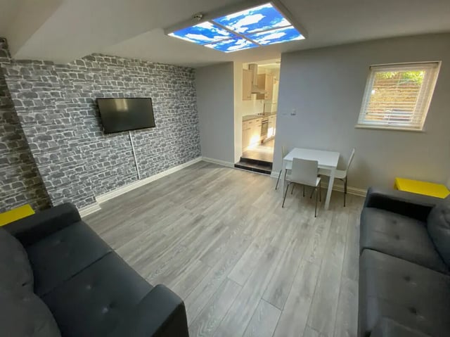 Two sofas table chairs kitchen area Living room at 6 Bedroom House at 59, Trafford Street in Preston Student Accommodation