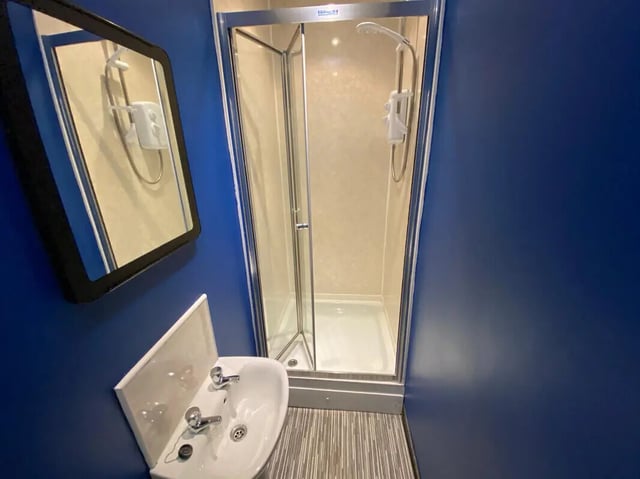 Sink shower mirror and blue walls bathroom at 6 Bedroom House at 59, Trafford Street in Preston Student Accommodation