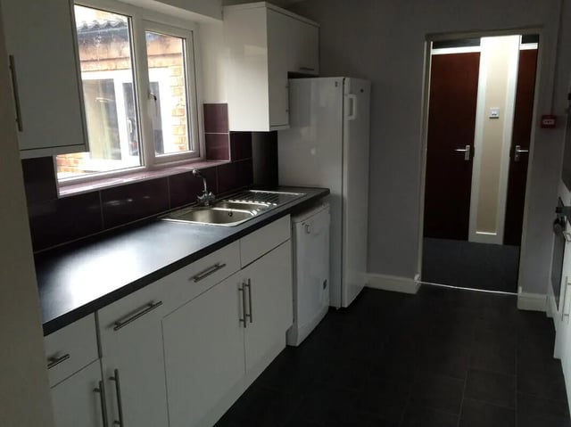 White cabinets sink and refrigerator kitchen at 8 Bedroom House at 73, Dallas Street in Preston Student Accommodation