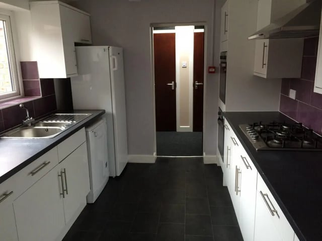 White cabinets sink stove refrigerator and doors kitchen at 8 Bedroom House at 73, Dallas Street in Preston Student Accommodation