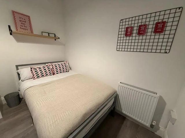 Bed with patterned pillows shelf art heater Bedroom at 8 Bedroom House at 73, Dallas Street in Preston Student Accommodation