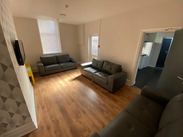 Gray couches on wood floor living room at 8 Bedroom House at 73, Dallas Street in Preston Student Accommodation