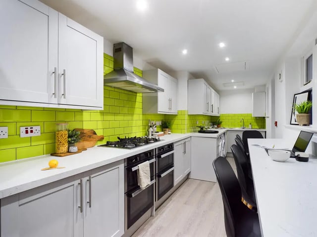 Modern kitchen with white cabinets bright green tiles kitchen at 6 Bedroom House at 146, Jubilee Drive in Liverpool Student Accommodation