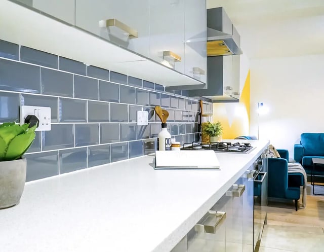 Modern kitchen counter with stove plant and living area Kitchen at 6 Bedroom House at 148, West Parade in Lincoln Student Accommodation