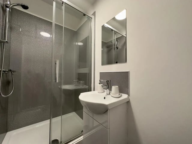 Shower stall sink and mirror student bathroom at 6 Bedroom House at 43, Monks Road in Lincoln Student Accommodation