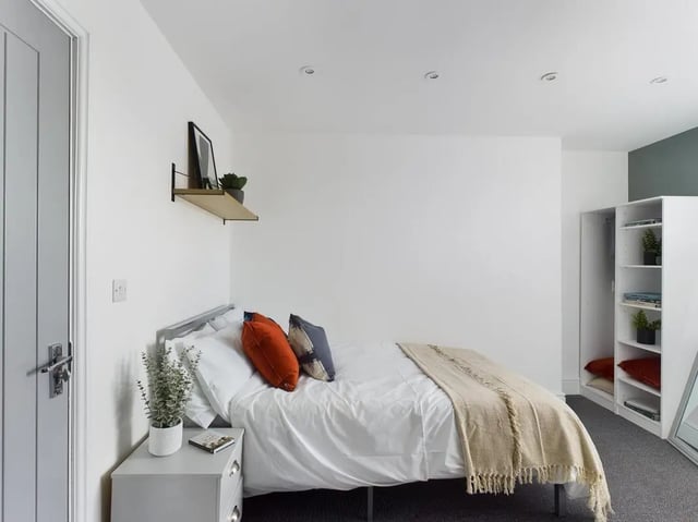 Bed with white bedding and orange pillows bedroom at 6 Bedroom House at 47, Monks Road in Lincoln Student Accommodation